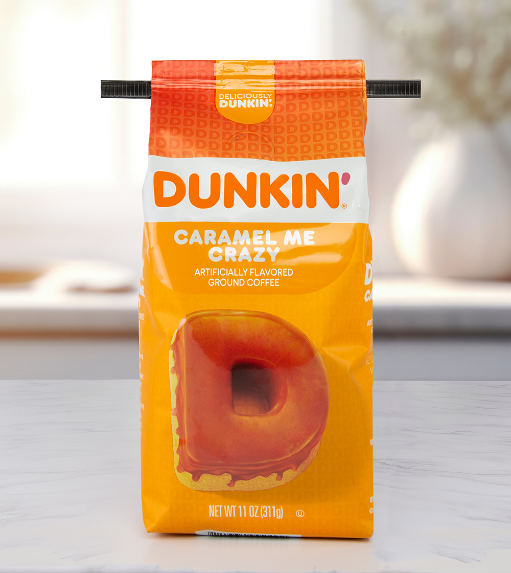 A black coffee bag tie on an orange Dunkin' brand Caramel Me Crazy coffee bag.