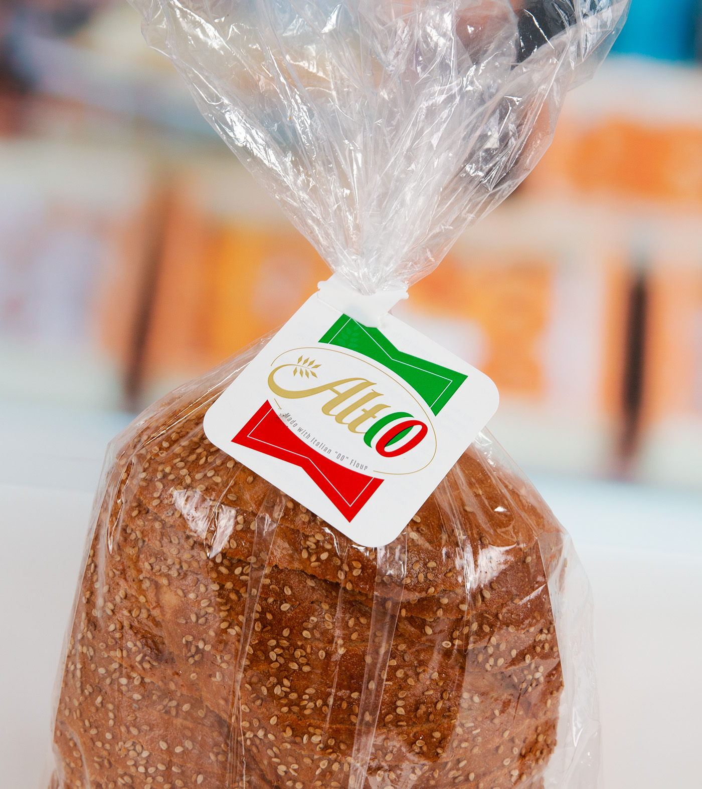 Loaf of seeded bread with Altoo branded bag flag in white, red, and green.