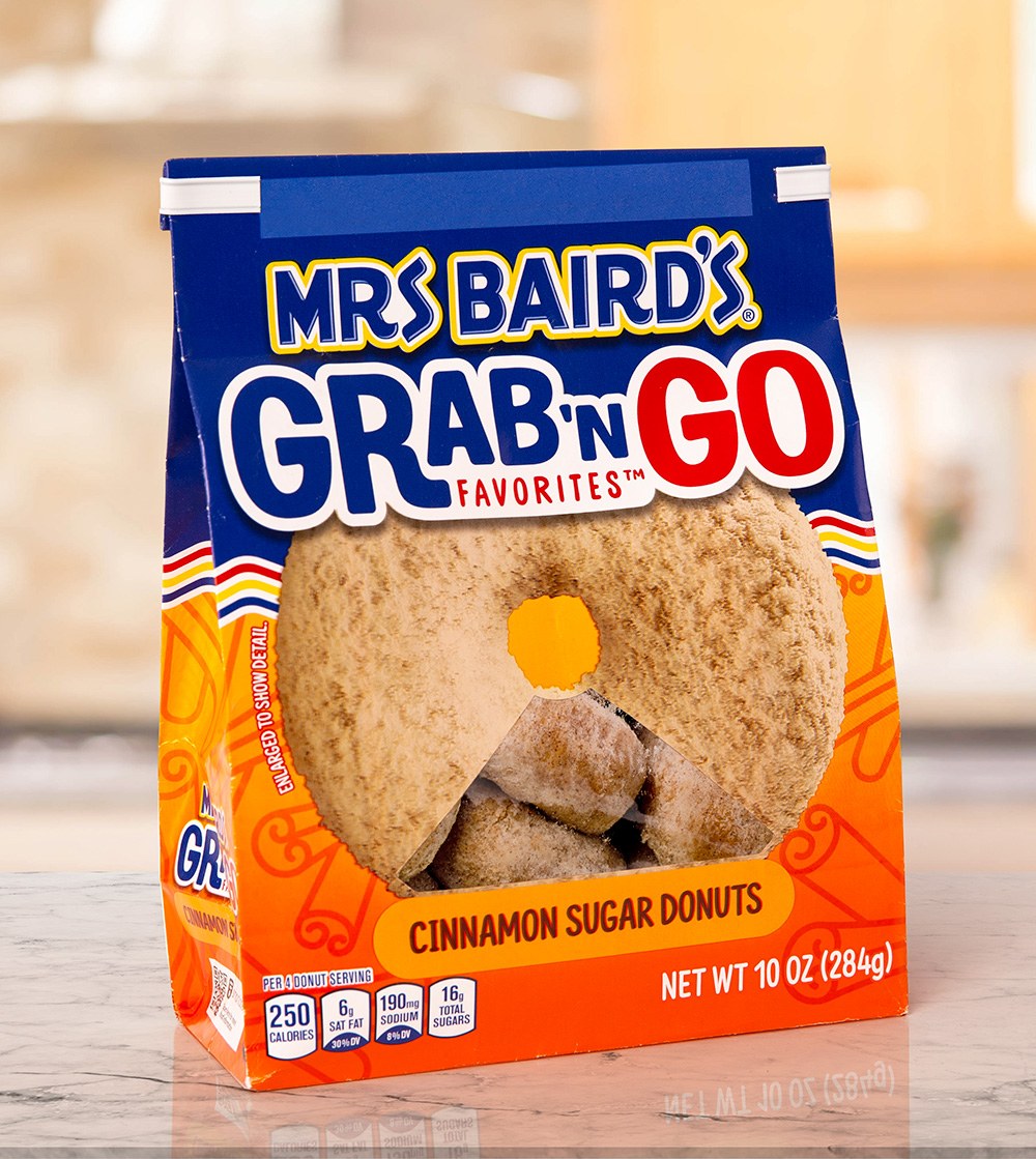 A white donut bag closure on a Mrs. Baird's brand mini cinnamon sugar flavor donuts.