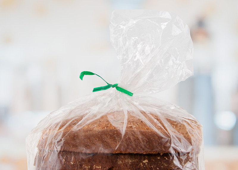 A bread bag with green twist tie highly focused.