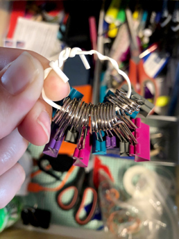 A white plastic wire tie holds document clips together.