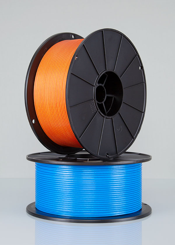 Two spools of twist tie, one orange and one blue, stacked on top of each other.