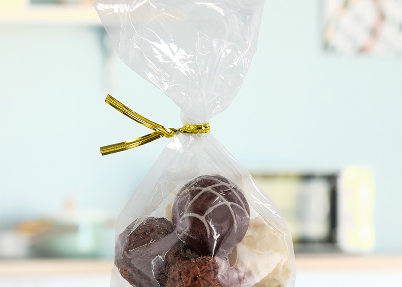 A gold metallic twist tie securing a bag of chocolate truffles.