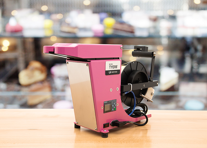 Pink twist tying machine in a candy store.