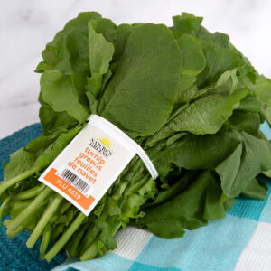 A produce tie with barcode tag keeps stalks of fresh, turnip greens bundled.