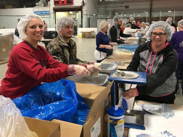 Three Bedford employees bag food to be distributed through the Feed My Starving Children organization.