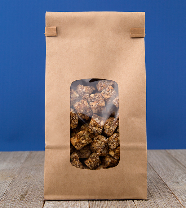 A paper tin tie secures a paper bag with transparent window showing granola bites.
