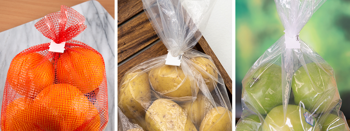 Compostable bag clips on potatoes, oranges, and apples.