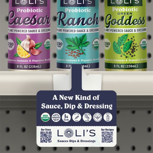 Three bottles of LOLI'S Probiotic Sauces and Dressings in flavors Caesar, Ranch, and Green Goddess, with a shelf talker below advertising them as a new kind of sauce, dip, and dressing.